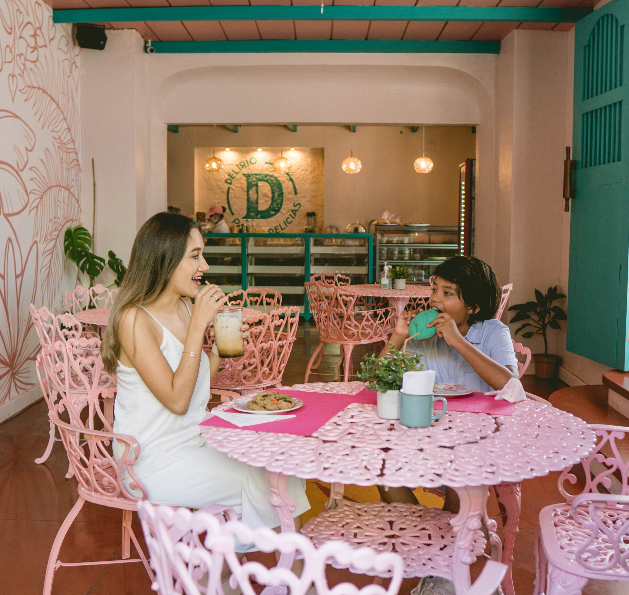 Interior de Delirio con mesas rosadas y clientes